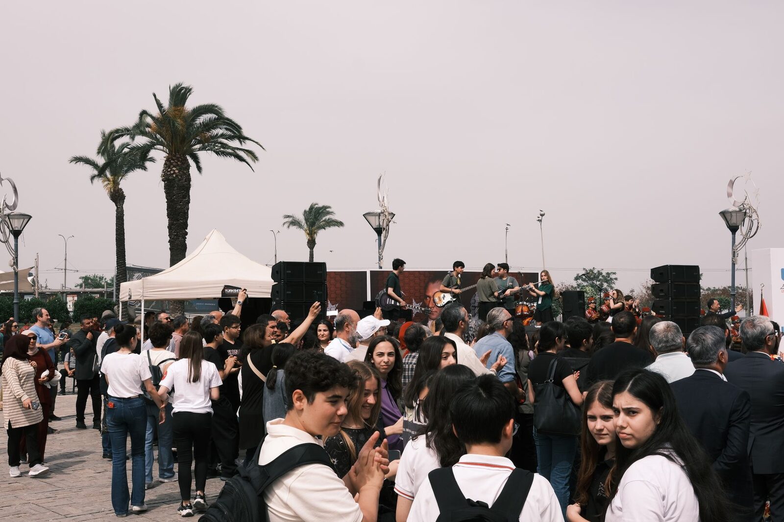 A bustling outdoor concert in İzmir with an engaged crowd and live band performance.